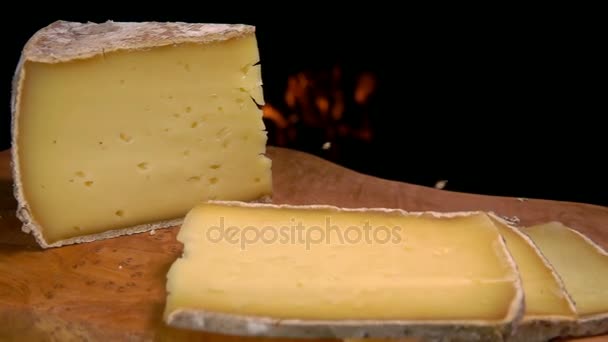 Slices of solid sheep cheese falling on a wooden board — Stock Video