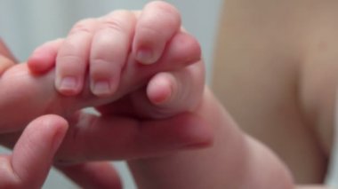 Bir yetişkin el parmakları ile tutarak bebek
