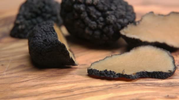 Кусочки черного трюфеля лежат на деревянной доске — стоковое видео