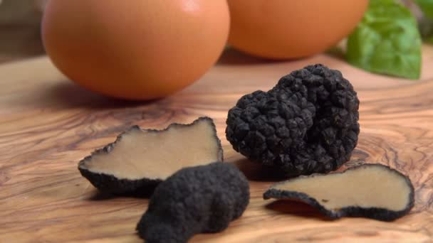 Segmenten en knollen van zwarte truffel liggend op de achtergrond van eieren — Stockvideo