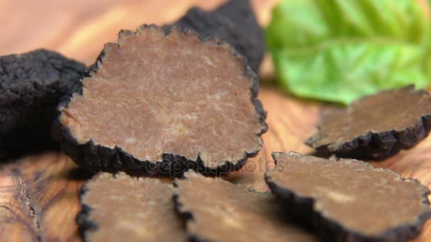 Шматочки чорного трюфеля лежать на дерев'яній поверхні — стокове відео