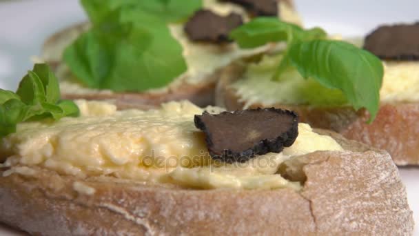 Aperitivo de ciabatta con crema de queso y rodajas de trufa negra — Vídeo de stock