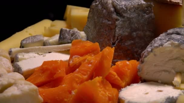 Pieces of french cheese on a black table. — Stock Video