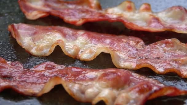 Gros plan d'une tranche de bacon frit sur le gril — Video