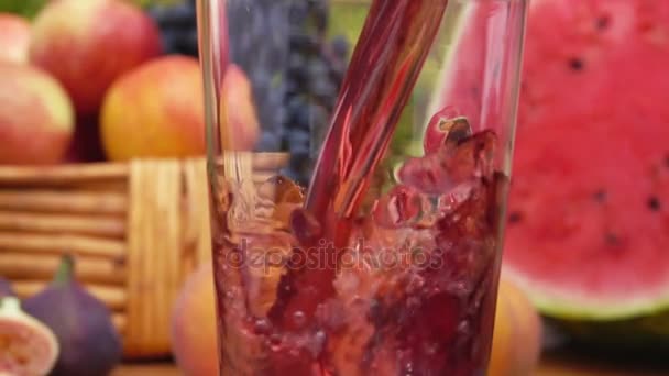 Mehrfruchtsaft wird in ein Glas gegossen. Zeitlupe. — Stockvideo