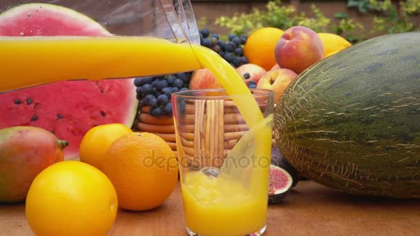 Апельсиновый сок наливают в стакан — стоковое видео