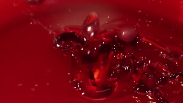 Grãos caindo em uma tigela de vidro com o suco — Vídeo de Stock