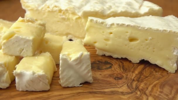 Detailní záběr z Kostičky sýra brie na dřevěné desce — Stock video