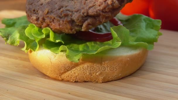 Putting burger on the bun and lettuce — Stock Video