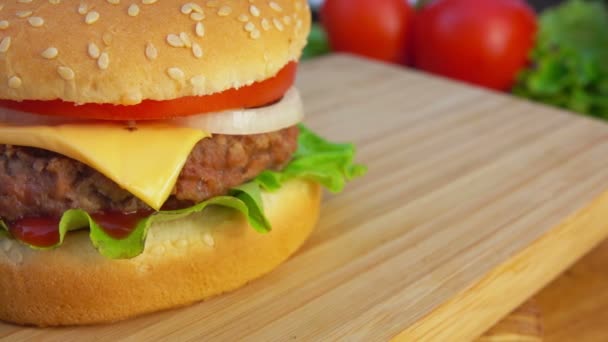 Hamburger with cheese and tomatoes on the table — Stock Video