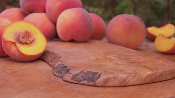 Slices of peaches falling on the wooden table — Stock Video