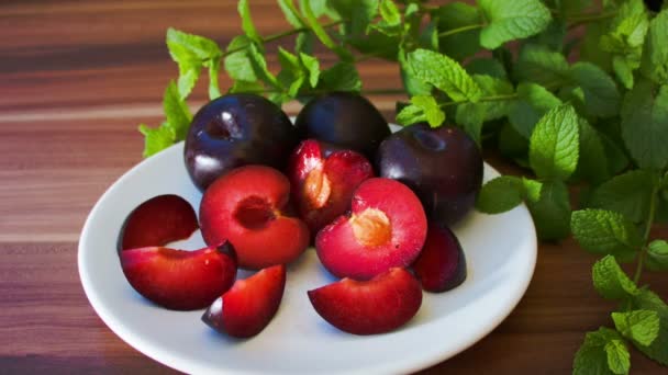 Ripe tasty plums on a white plate — Stock Video
