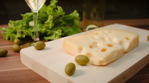 Pedazo de queso Maasdam en una tabla de madera — Vídeo de stock