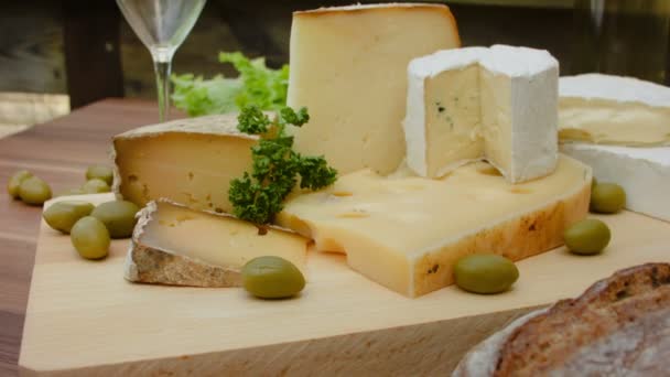Pedaços de queijo numa tábua de madeira — Vídeo de Stock