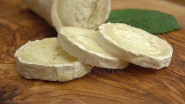 Long goat cheese is taken by fork from board — Stock Video