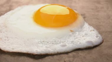 Cook kızarmış yumurta bir spatula ile alır.