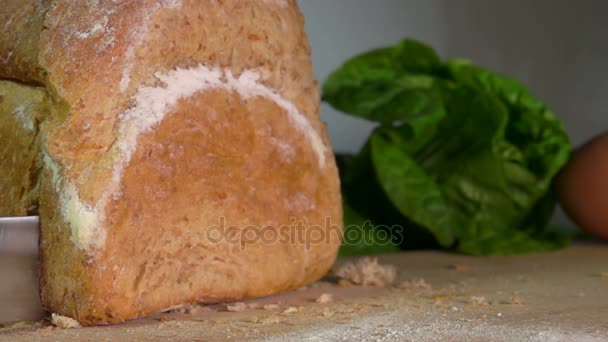 El pedazo del pan cortado de la hogaza cae sobre la tabla — Vídeo de stock