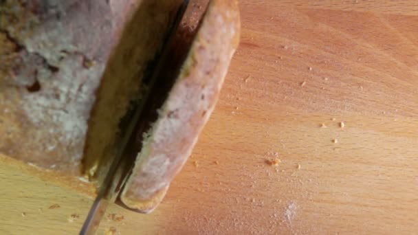 Movimiento lento del cuchillo cortando un pan de pan de grano de pan — Vídeos de Stock