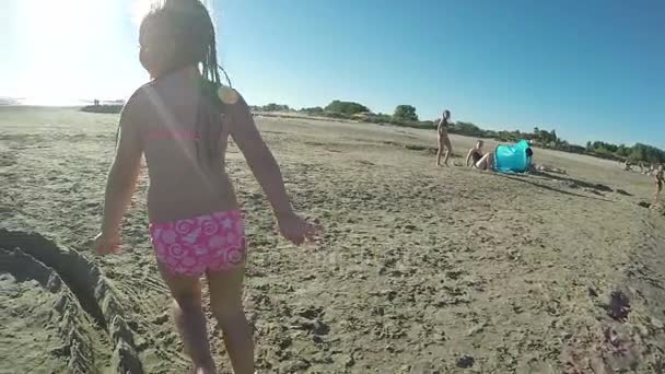 Kleines schönes Mädchen, das im Sand rennt — Stockvideo