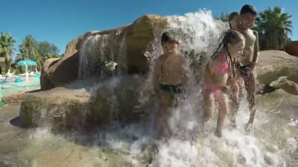 Маленькие красивые дети стоят под струями воды — стоковое видео