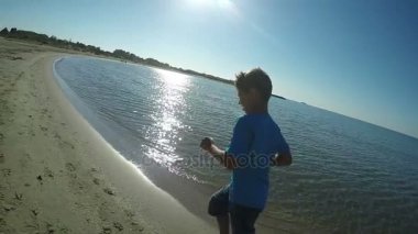 Oğlan mavi tişört sahil çalışır