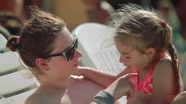 Mulher de óculos de sol segura uma filha em seus braços — Vídeo de Stock