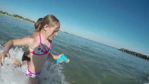 Niño y niña jugando con pistolas de agua — Vídeo de stock