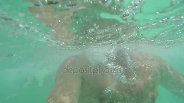 Чоловік тримає дихання і занурюється під воду — стокове відео