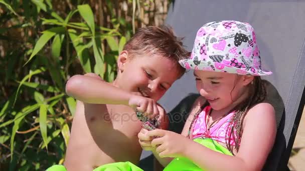 Niña y niño descansando en las tumbonas — Vídeo de stock