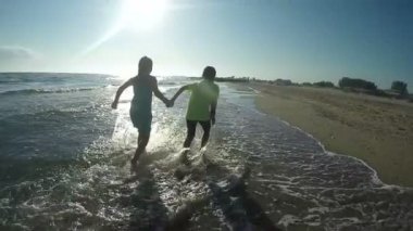 Kız ve erkek sörf hattı boyunca su çalıştırmak