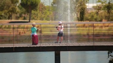 Küçük sevimli çocuklar el ele tutuşup köprüyü