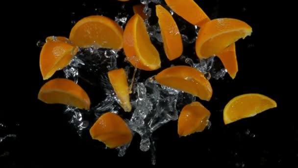 Orangenscheiben mit Wasser fliegen in die Kamera — Stockvideo