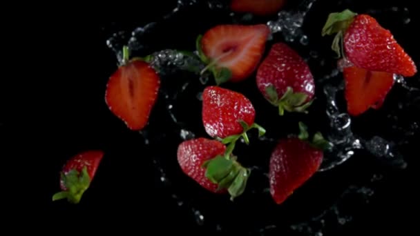 Sappige aardbei met water vliegen naar de camera — Stockvideo