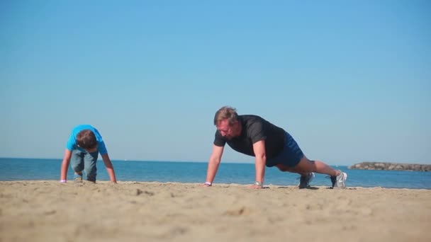 Menino e homem fazendo exercícios esportivos — Vídeo de Stock