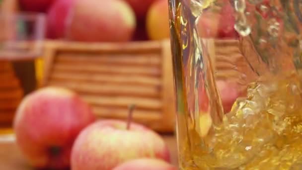 Sumo de maçã suco é derramado em um copo e cesta maçãs — Vídeo de Stock