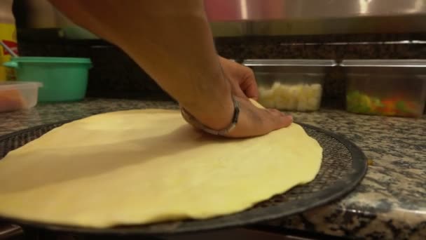 Pizzateig wird auf einer Backform ausgebreitet — Stockvideo