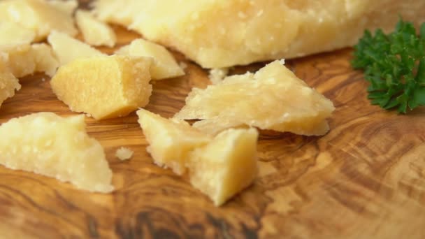 Fork takes piece of Parmesan cheese from the wooden board — Stock Video