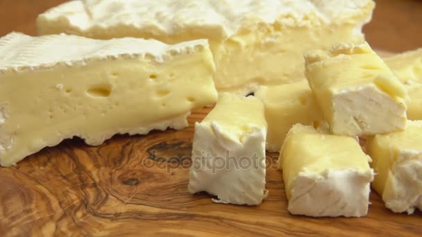 Close up de cubos de queijo brie em tábua de madeira — Vídeo de Stock