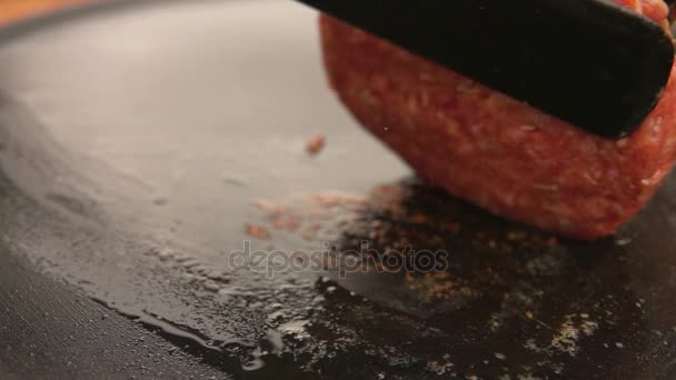 Бургер перевернулся на гриле с кухонным лопаткой — стоковое видео