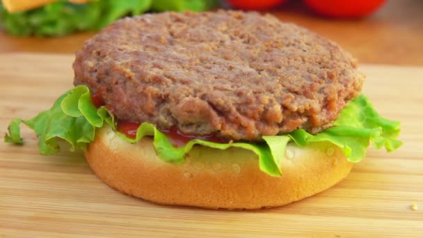 Cheddar cheese is placed on a burger — Stock Video