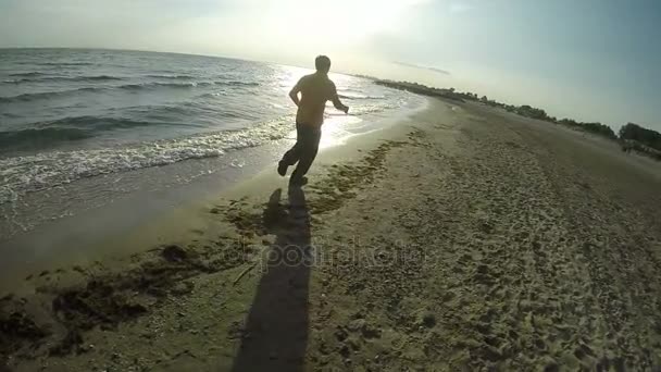 O homem corre ao longo da linha do mar — Vídeo de Stock