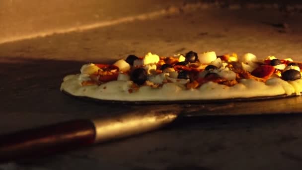 Cozinheiro gira a pizza com azeitonas e presunto dentro do forno — Vídeo de Stock