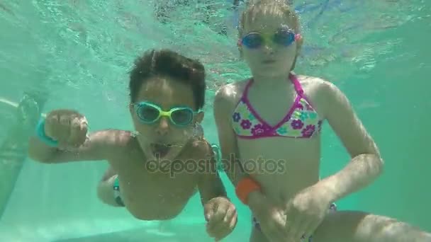 Niño y niña nadando bajo el agua — Vídeos de Stock