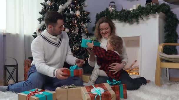 Familia joven abre regalos de Navidad — Vídeo de stock