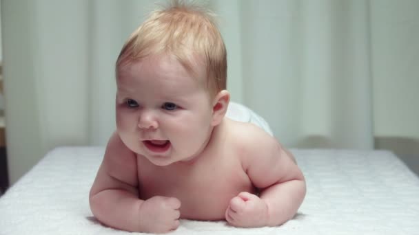 Little happy baby lies on his stomach — Stock Video