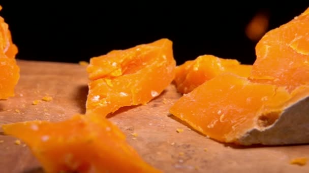 A parte de queijo de Mimolett cai em uma tábua de madeira — Vídeo de Stock