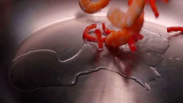 Garnalen en paprika zijn gegoten in een koekepan — Stockvideo