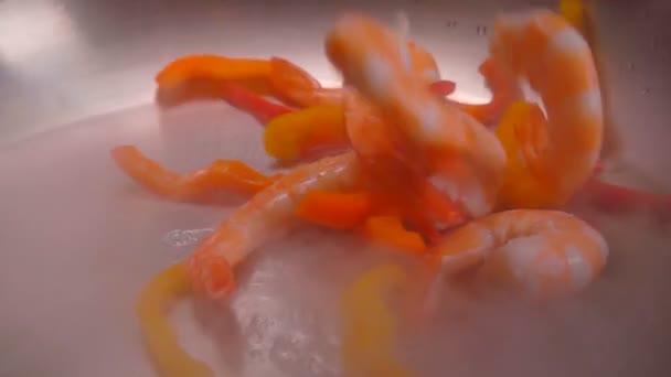 Очищенные креветки падают в сковороду с маслом — стоковое видео