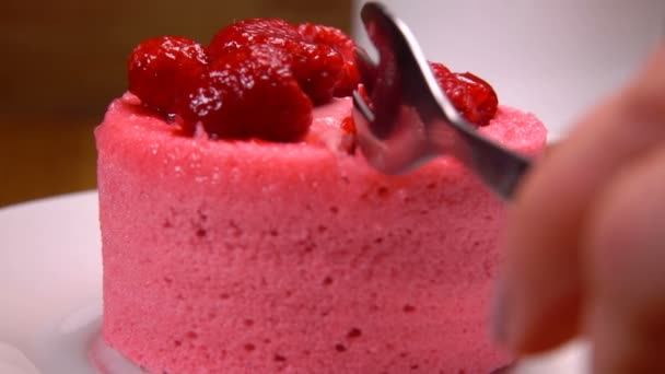 Fork takes a piece of French mousse cake with raspberry and cream — Stock Video