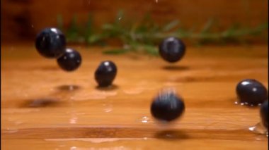 Islak yaban mersini düşer ve ahşap masanın üzerinde